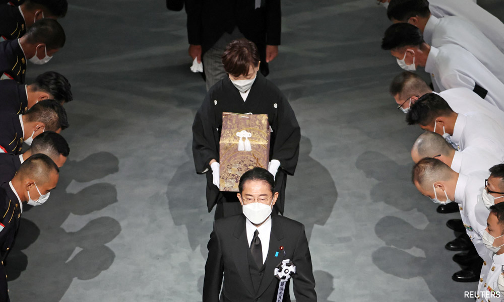 With flowers and a gun salute, Japan bids farewell to divisive Abe