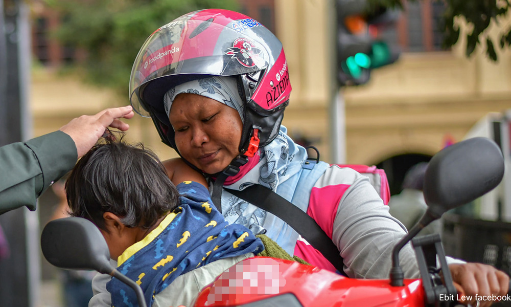 Delivery rider mum carries child while working, remains hopeful