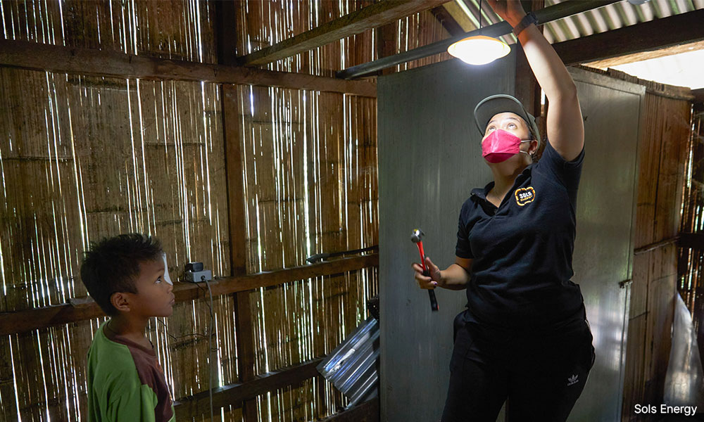 Sols Energy installing a solar-powered light in an Orang Asli home.