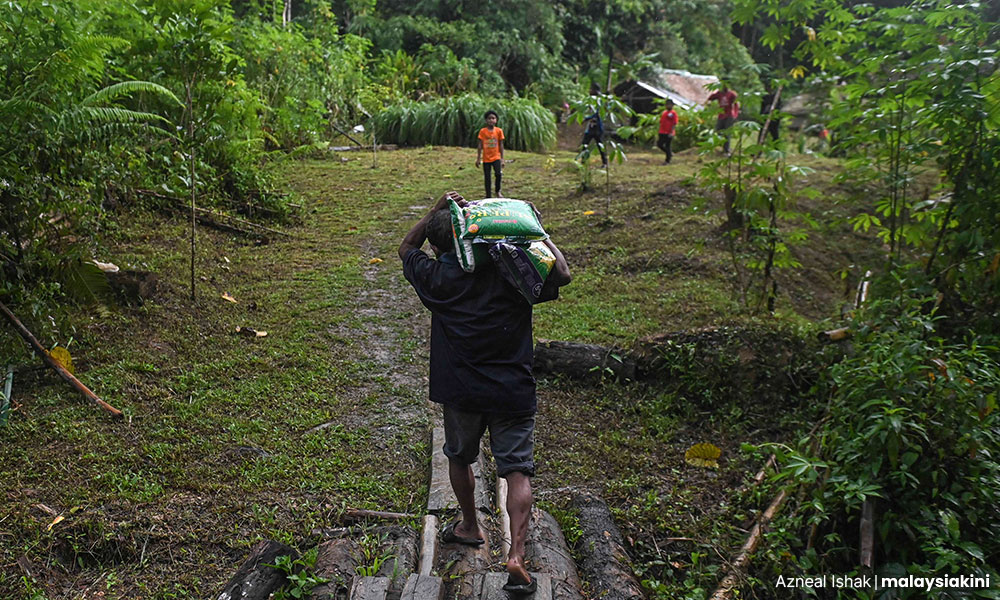 Penduduk kampung membawa pulang seguni beras sumbangan sukarelawan.