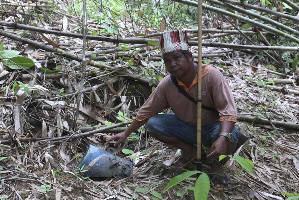 Seorang penduduk menunjukkan sebuah kubur. Menurut adat kaum Temiar, pisau-pisau lama akan ditanam di kubur. Banyak kubur telah diceroboh, kata mereka.