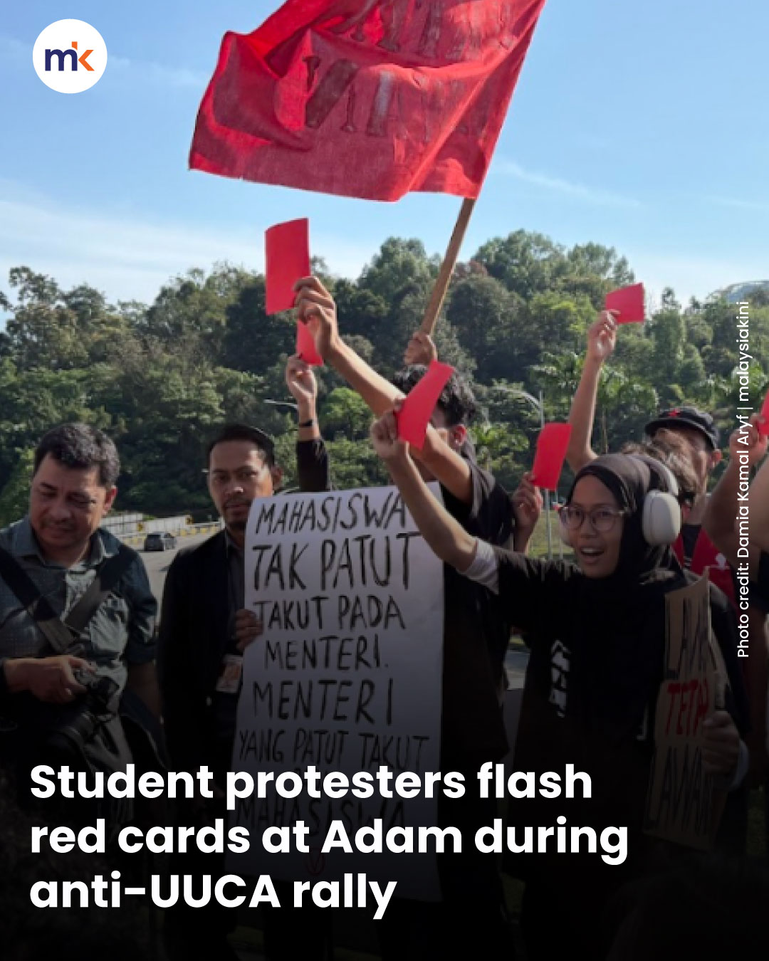 Student protesters flash red cards at Adam during anti-UUCA rally